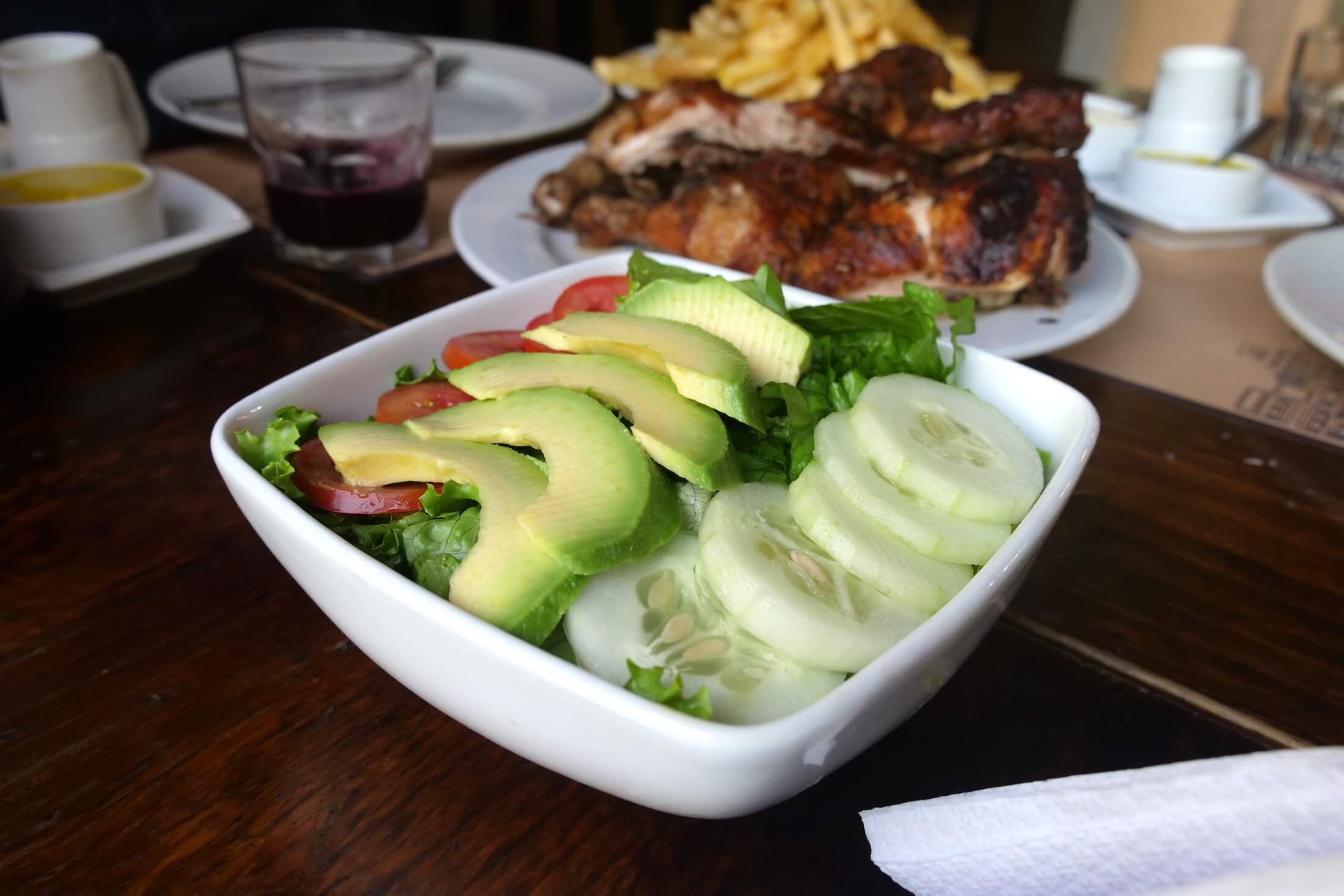 simple and clean plate of crunchy vegetables and avocado to accompany your Pollo a la Brasa